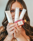 Woman holding VIBRANT® RESTORE Barrier Repair Moisturizer with Vibrant Skin microbiome-friendly skincare collection