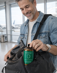 Man in an airport holding a bottle labeled 'Vibrant D' and a bag.