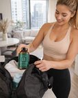 Woman in athletic wear holding a bottle of Brazyl supplement in a home setting.