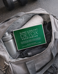 Gray bag with a '14 Day Vibrant Detox Vegetarian' supplement package and water bottle.