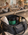 Black duffel bag with 'Vibrant Collagen' container, towel, and water bottle on a Pilates reformer machine.