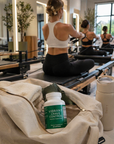 Middle-aged woman working out in a modern gym with a Vibrant Crave Control bottle visible inside an open gym bag in the foreground.