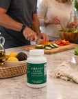Supplement bottle labeled 'Vibrant Crave Control' on a kitchen counter with people preparing food in the background.