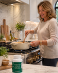Woman cooking in a kitchen with a bottle of Vibrant Crave Control on the counter.