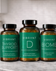 Three bottles of Vibrant Health supplements on a kitchen counter.