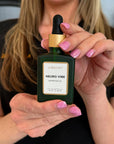 Woman in spa holding Vibrant Neuro Vibe Superfood Oil serum in her hand