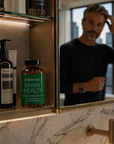 Bathroom counter with a bottle labeled 'Vibrant Brain Health' and a man's reflection in the mirror.