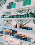 Shelves with various skincare products against a leaf-patterned wall