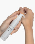 Hand applying VIBRANT® RESTORE Barrier Repair Moisturizer to skin on white background