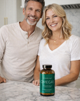 Man and woman standing behind a bottle of Ombrant Omegas on a kitchen counter.