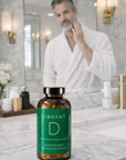 Man in a bathroom applying cream to his face with a bottle of 'Vibrant D' supplements on the counter.