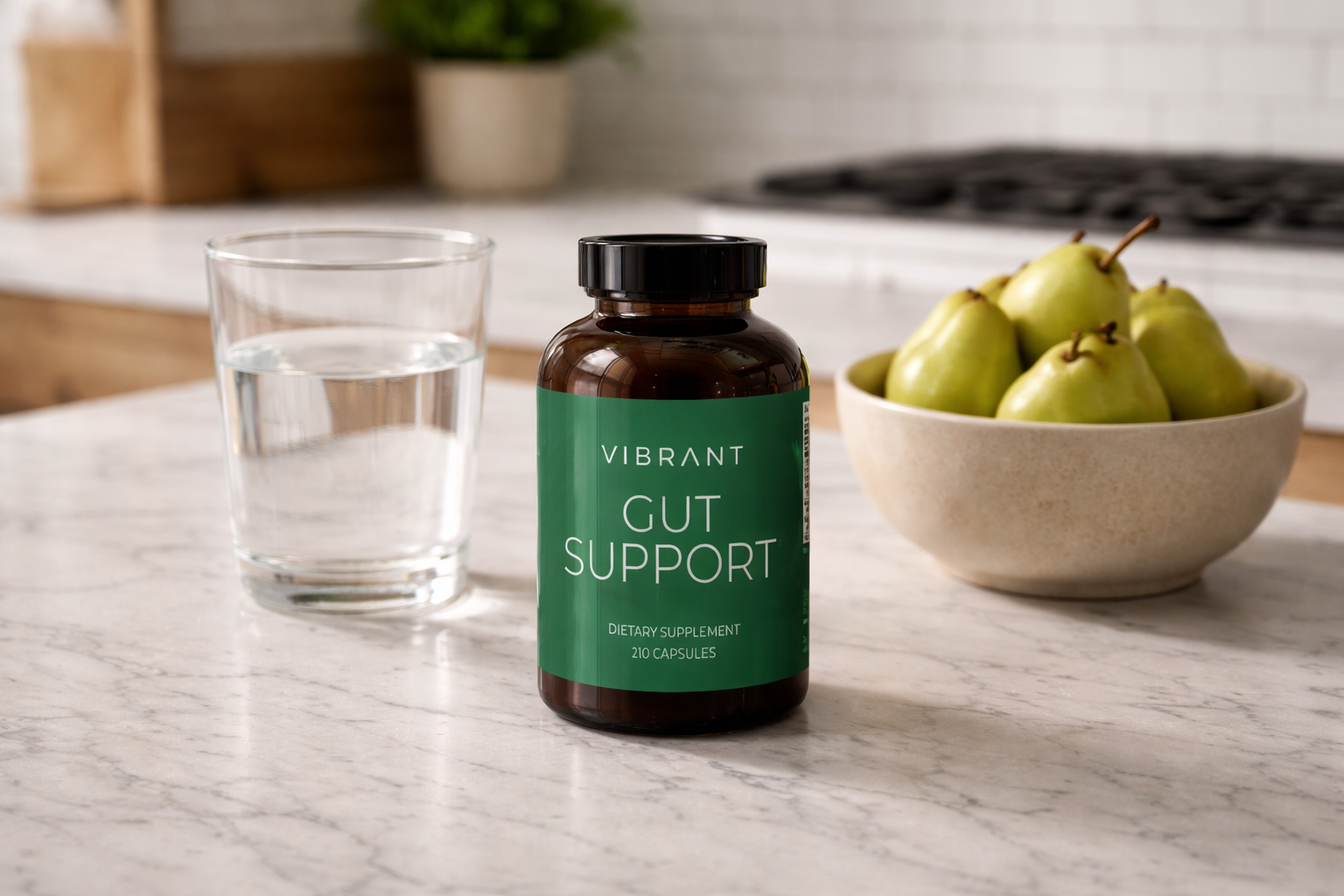 Vibrant Gut Support supplement bottle on a kitchen counter with a glass of water and pears.
