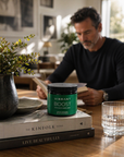 Man reading a book with a 'Vibrant Boost' container on a table
