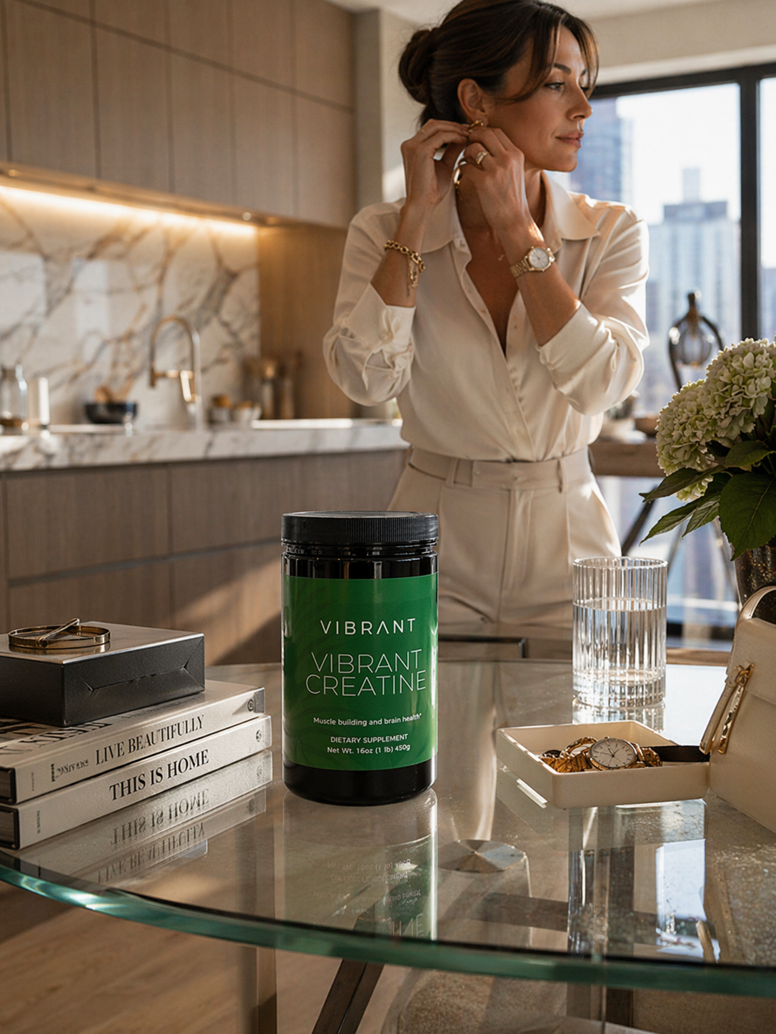 Woman adjusting earrings in a modern kitchen with a Vibrant supplement container on the counter.